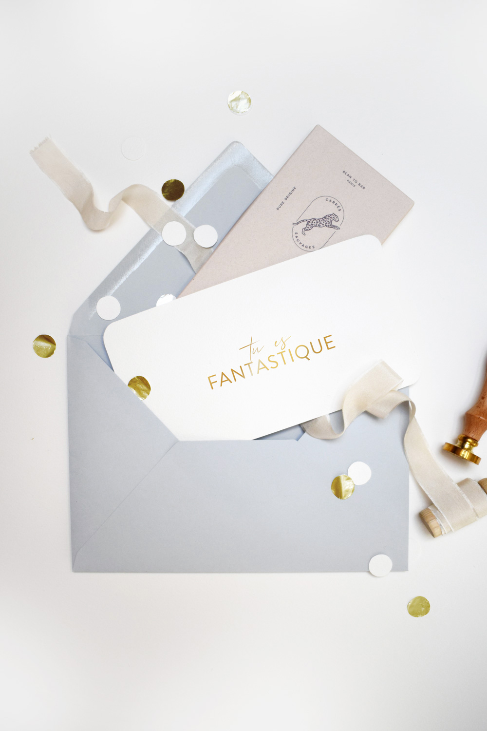 Une carte cadeau festive et élégante avec un joli carton doublé d'une tablette de chocolat dans une enveloppe calligraphiée