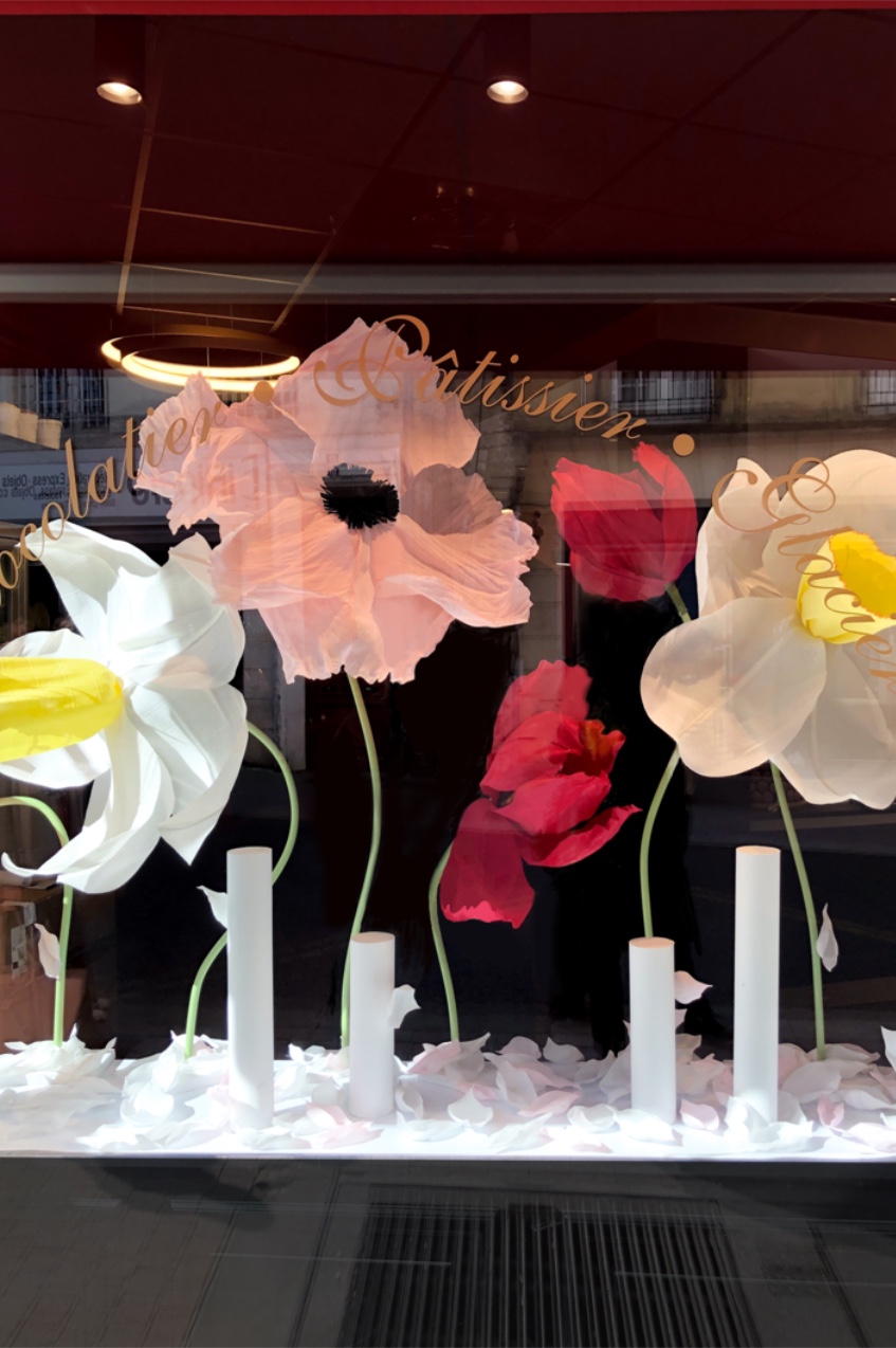 Vue globale de la vitrine du printemps pour le chocolatier Fink avec ses fleurs géantes en papier crépon