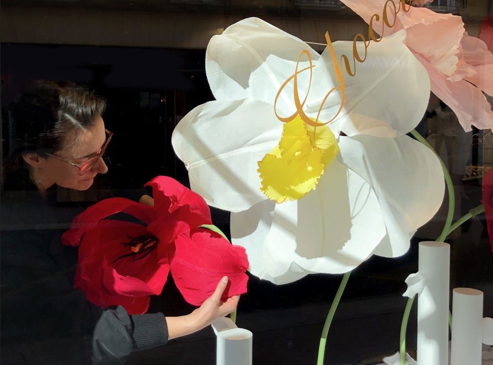 La scénographe vitirne Studio Raphaelle en train de courber les pétales des fleurs géantes